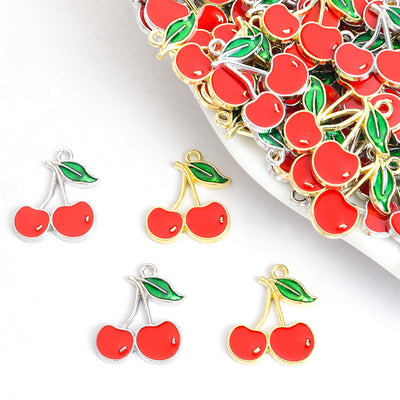 Front assortment of paired red cherries with green leaves and glossy enamel