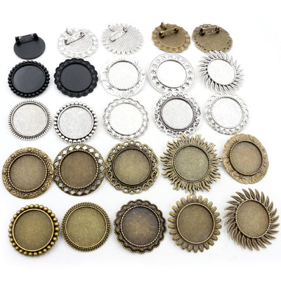 Front overview of decorative round brooch tray settings in mixed metal tones arranged on a light background
