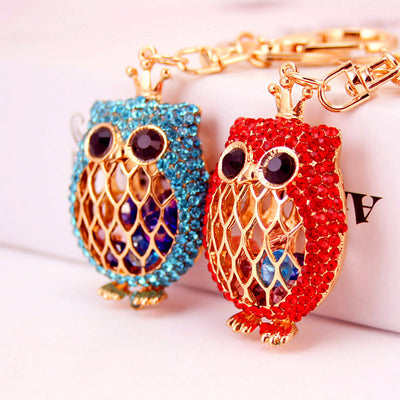 Red and blue crowned owl keychains with rhinestone edging and gold-tone lattice fronts.
