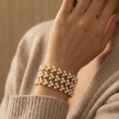 Gold pearl chevron bracelet worn stacked on wrist