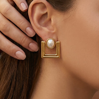 Display view of gold tone geometric square pearl center earrings in main image 1.