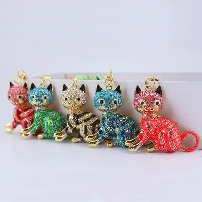 Five rhinestone sitting cat keychains in assorted colors arranged in a row.