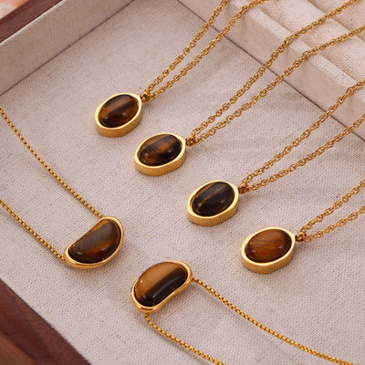 Gold tiger-eye oval and bean pendants arranged in jewelry tray