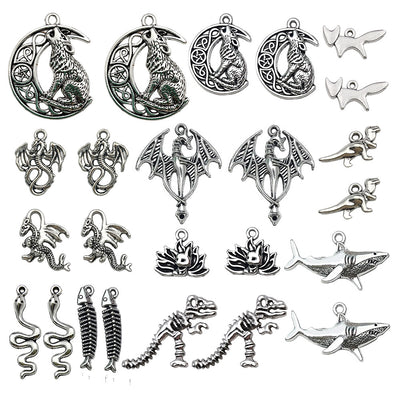 Antique silver fish charms arranged on a light background