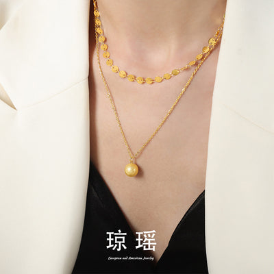 Gold layered disc chain and ball pendant worn on neck