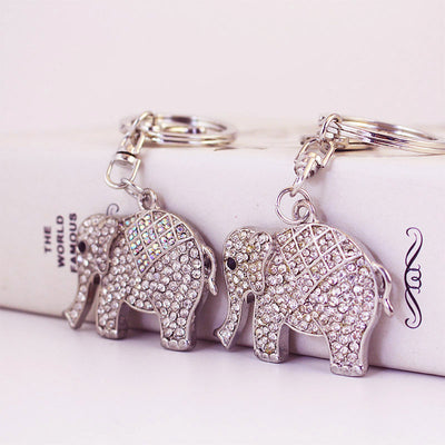 Two silver-tone elephant keychains displayed side by side with clear and iridescent rhinestone details.