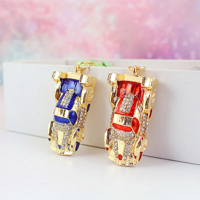 Red and blue gold-tone car charms stand side by side with clear rhinestone details.
