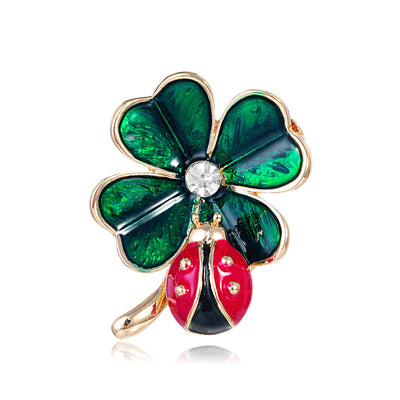 Front product view of an enamele broochi with green and red flowers