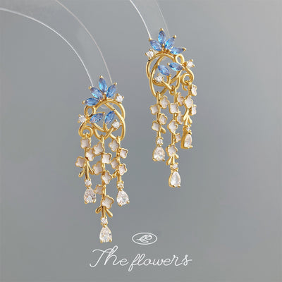 Gold blue flower cascade tassel earrings on clear acrylic stands
