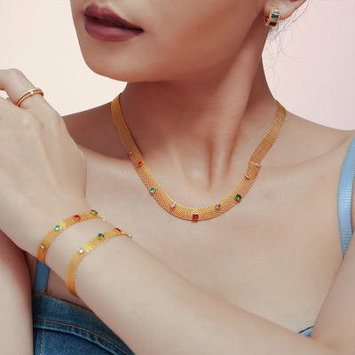 Model wearing gold mesh necklace with multicolor stones and matching bracelets