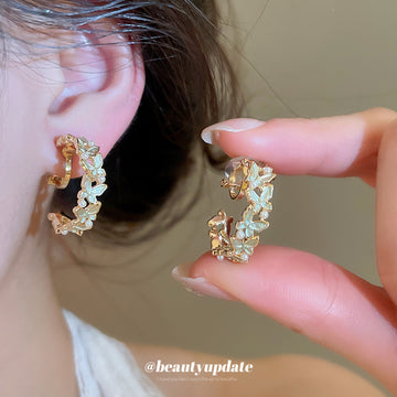 White Flower And Green Leaf Hoop Clip On Earrings With Polished Metal Details