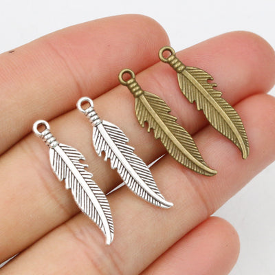 curved feather charm with engraved barbs assortment on a light background