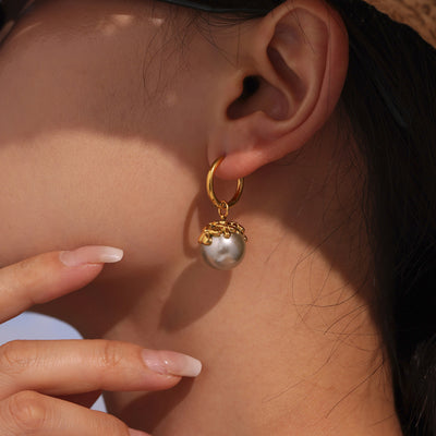 Model ear wearing gold hoop with gray shell pearl flower cap drop