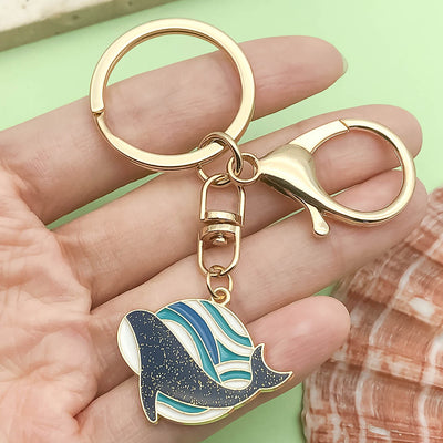 Image 1 showing a person holding up a gold keychain with a dolphin.
