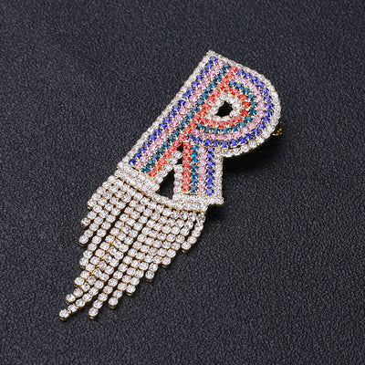 Front view of multicolor crystal letter r brooch with chain fringe
