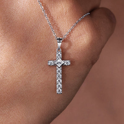 Silver pavé CZ cross pendant necklace resting on skin close-up