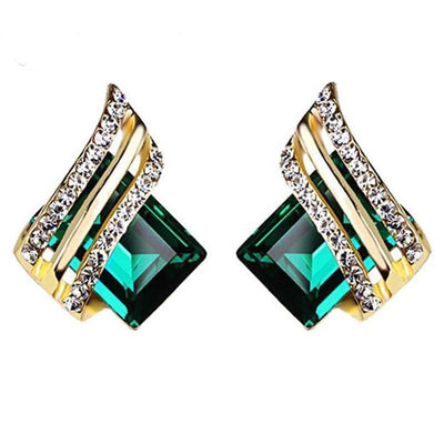 Pair of gold wing studs with emerald green square center stones