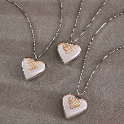 Grouped style view of oversized two tone crystal heart pendant necklace in main image 1.