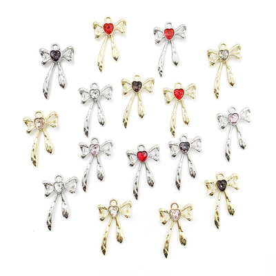 Metallic bow and butterfly charms arranged on a light background