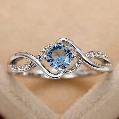 Silver-tone wave ring with blue round center stone