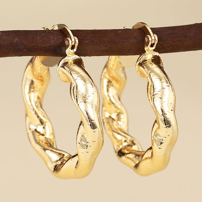 gold tone earrings showing chunky open hoops with a rippled uneven profile