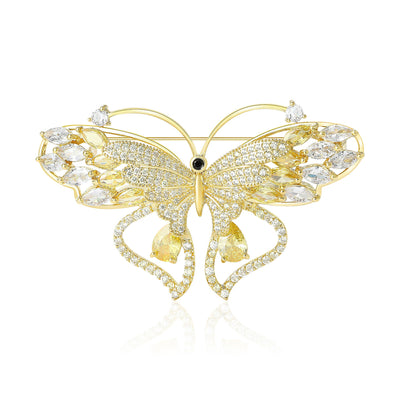 Front view of gold openwork crystal butterfly brooch against a white background.