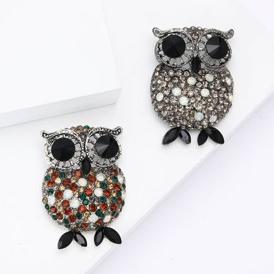 Front view of the crystal owl brooch with oversized black eyes decorative clothing pin on a white background