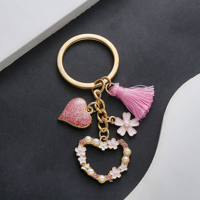 Front product photo of pink tassel pearl flower and open heart charm keychain showing the pictured design arrangement