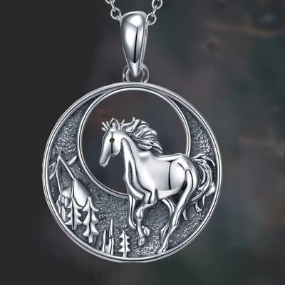 Close-up silver horse forest crescent pendant necklace dark background
