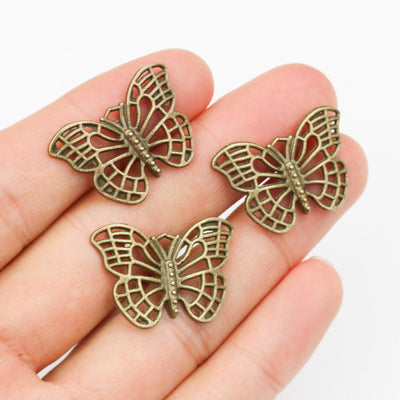 Antique Bronze Openwork Butterfly Alloy Charm Pendant, grouped overview on a plain background