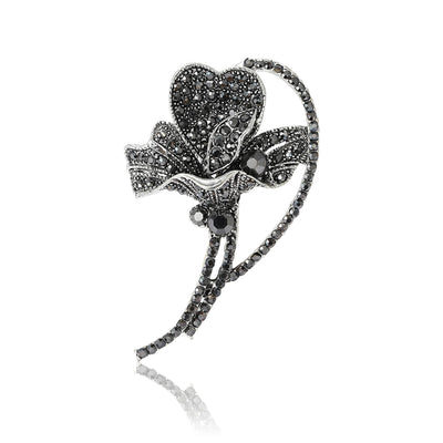 Black rhinestone flower brooch silver tone front reflection on white