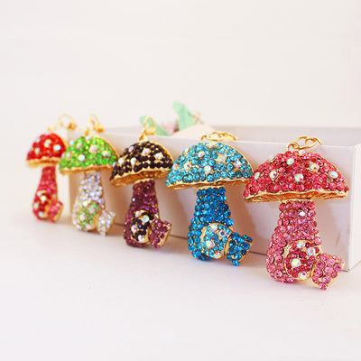 Five rhinestone mushroom pieces in red, green, purple, blue, and pink color combinations.