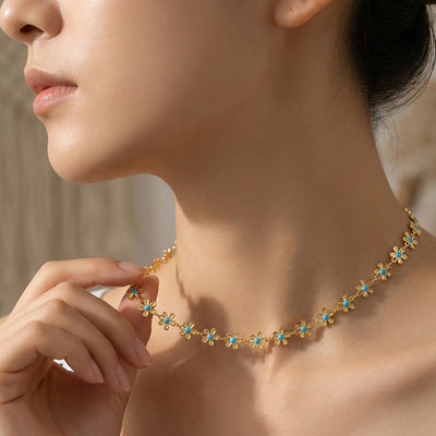 Model profile wearing gold blue-center mini flower chain necklace