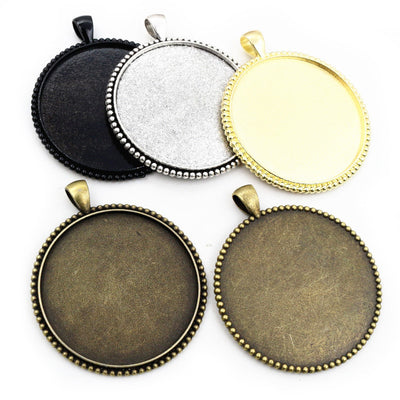 Large Round Pendant Bezel Setting Trays in Four Finishes assortment on a plain background