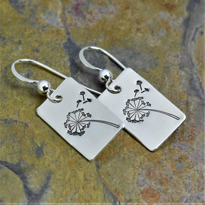 Silver dandelion rectangle hook earrings angled on multicolor stone