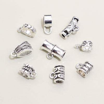 Overview of antique silver tone three way large hole connector beads arranged on white