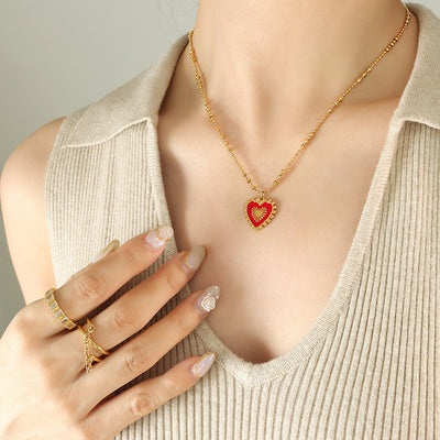 Gold ball chain red enamel sunburst heart pendant on model neck
