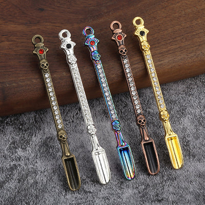 Five elongated skull scoop charms in bronze, silver, rainbow, copper and gold finishes.