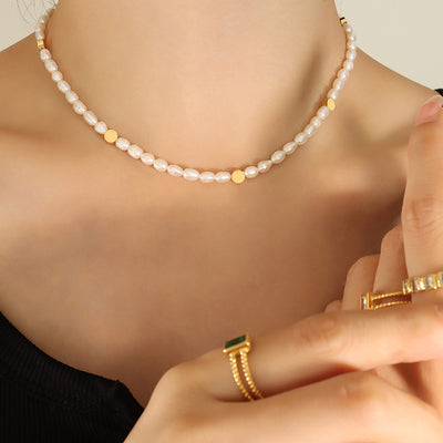 Baroque pearl necklace with gold discs worn on collarbone