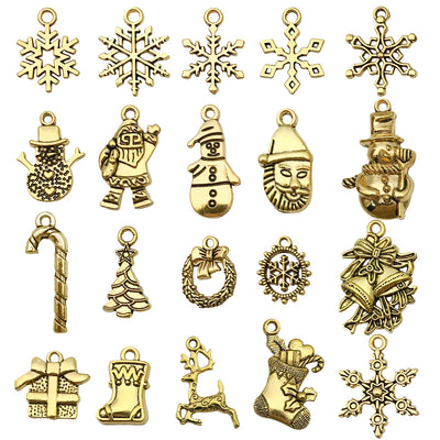 Matte gold-tone snowflake and christmas tree charms arranged on a light background