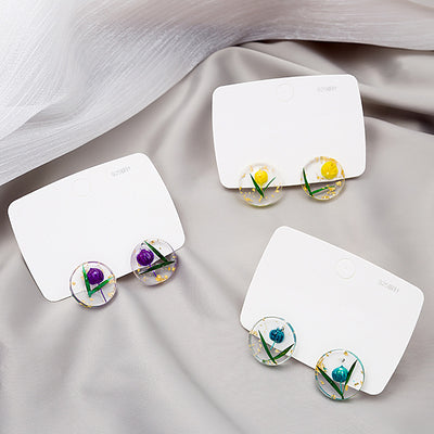 Purple yellow and teal dried flower resin studs on white cards with 925 marks
