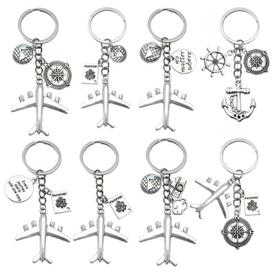 A collection of silver-tone airplane and nautical keychains is arranged on a white background.