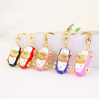 Five car keychains in black, red, peach, blue, and bright pink stand side by side.