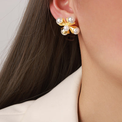 White pearl gold cross stud worn on ear close-up
