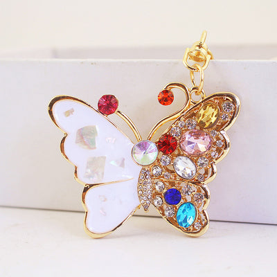 Front view of a gold-tone butterfly keychain with pale and multicolor wings.