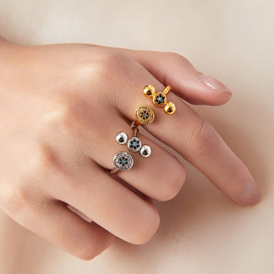 Gold and steel open ball pavé disc rings stacked on model fingers