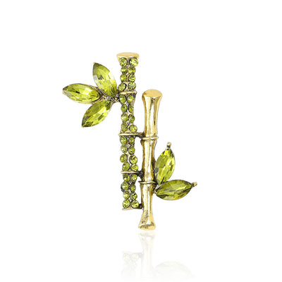 Front view of bamboo branch crystal brooch with green leaves and gold tone stems
