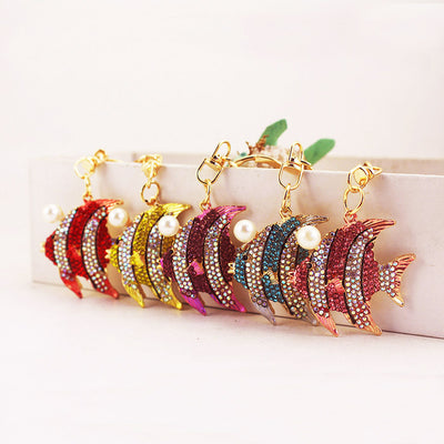 Five jeweled striped fish keychains displayed in red, gold, purple, blue, and pink colors.