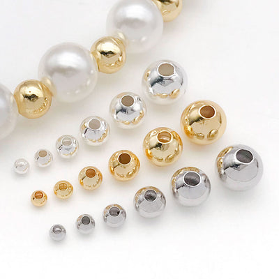 Front overview of smooth round metal spacer beads in six sizes arranged by finish and size