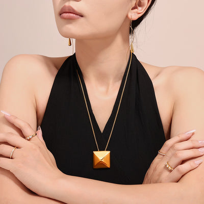 Gold pyramid square pendant necklace worn with black halter
